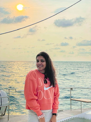Aarya smiling on a boat at sunset